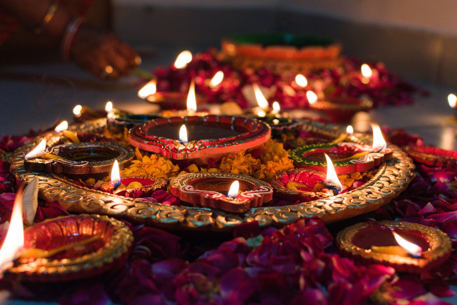 Lit clay diyas decorated with marigold flowers for Diwali