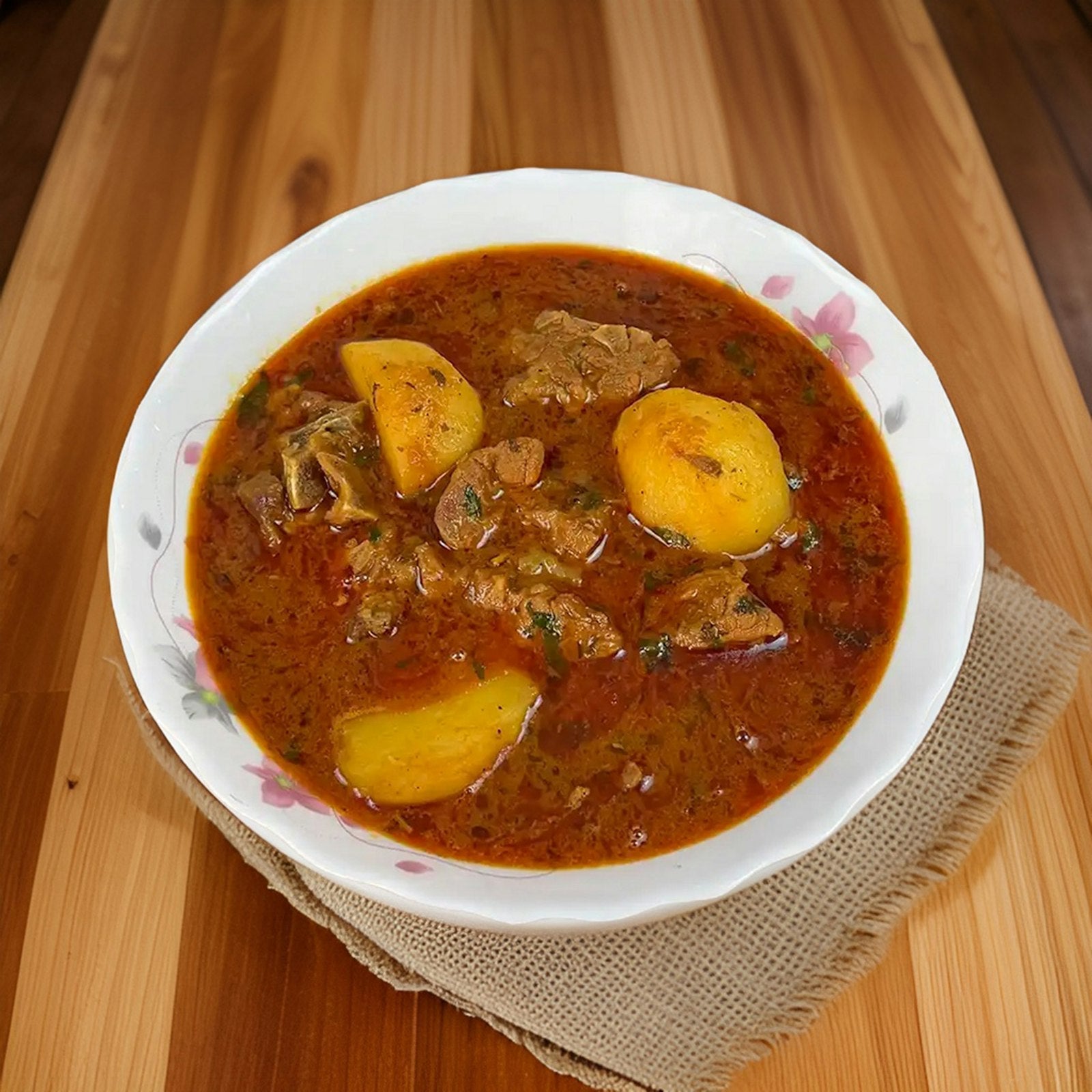 Bowl of rich meat curry on a wooden table