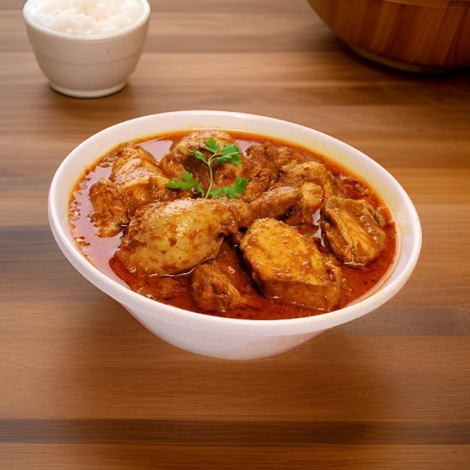 Bowl of chicken curry served with a bowl of rice