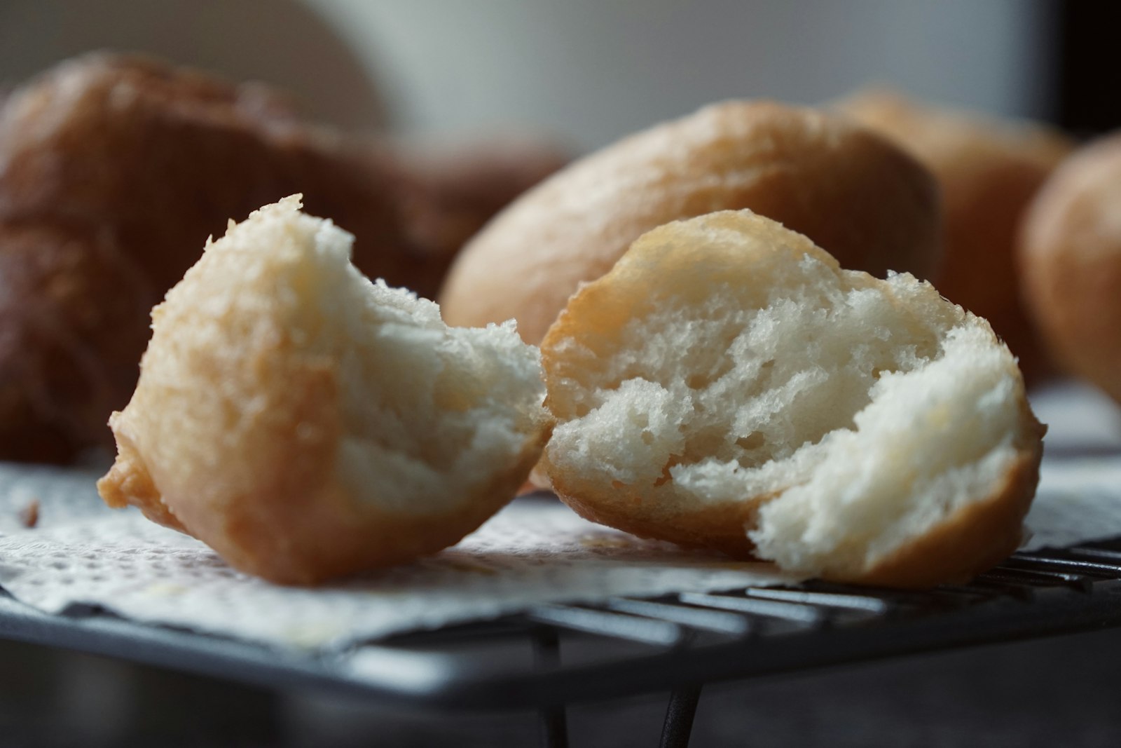 Golden fried sweet dough balls on a cooling rack
