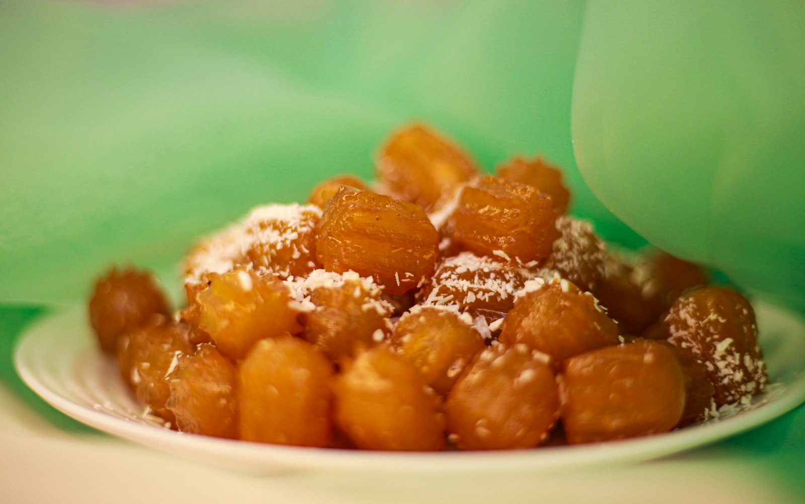 Pile of golden fried dough balls sprinkled with coconut